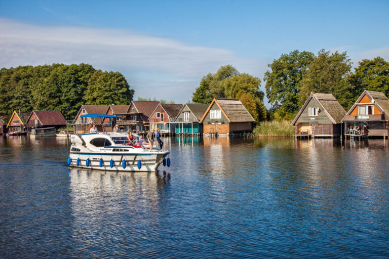 Haines vor bunten Ferienhäusern mit Frauen als Bootscrew