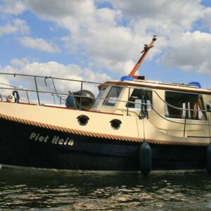 Außenansicht der Grommer 800. Ein schwarz-beiges Boot das auf der Müritz ankert.