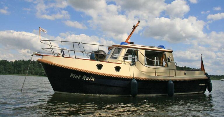 Außenansicht der Grommer 800. Ein schwarz-beiges Boot das auf der Müritz ankert.