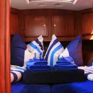 Bezogene Kojen der Grommer 800. Ein Doppelbett mit blau-weißen Bezügen.