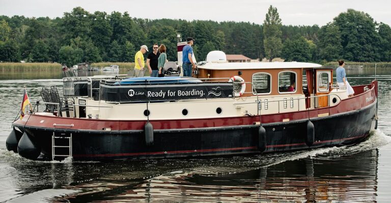 Außenansicht des Bootes Aquanaut, 5 Personen sind an Deck