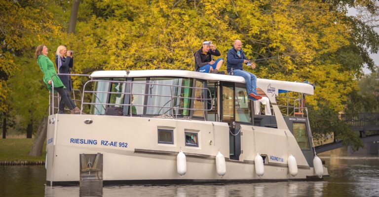 2 Frauen und 2 Männer an Deck der Aquino im Herbst, eine Person angelt