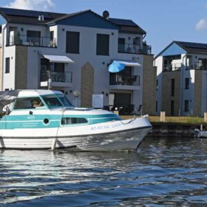 das Boot Bellus fährt durch den Kanal in das Hafenbecken einer Marina