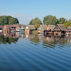 Eine Reihe bunter Bootshäuser an der Müritz.