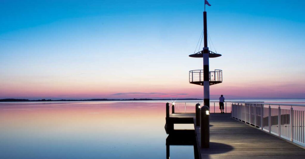 Die Seebrücke im Hafendorf Müritz bei Sonnenuntergang.