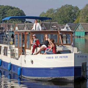 Eine Kormoran vor einer Reihe von bunten Bootshäusern.