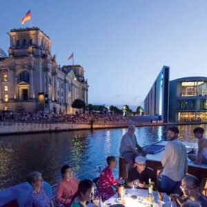 Gruppe von Menschen am Reichstaggebäude am Abend