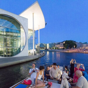 Gruppe von jungen Leuten in Berlin am Abend auf der Spree