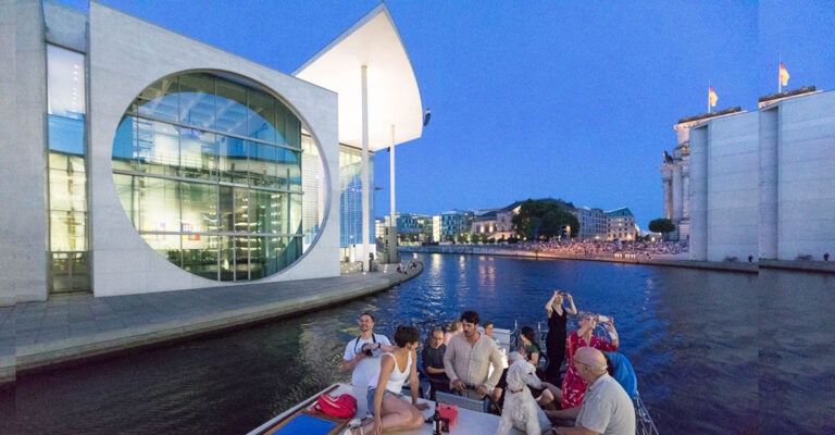 Gruppe von jungen Leuten in Berlin am Abend auf der Spree