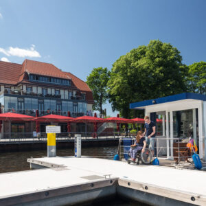 Ein Hausboot im Hafen an einer Gaststätte