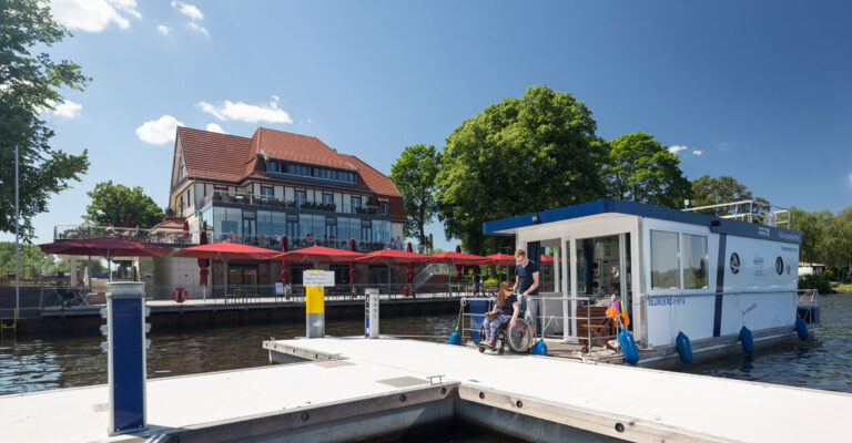 Ein Hausboot im Hafen an einer Gaststätte