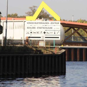 Ein Schild im Kanal zu Königs Wusterhausen mit Richtungsweiser zum Zentrum sowie der Stadtschleuse.