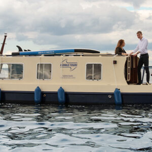 Seitenansicht der Kuinder. Ein blau-beiges, längliches Boot.