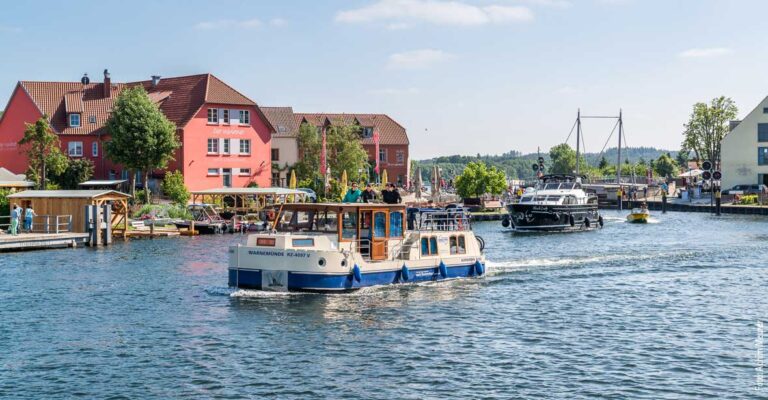 eine Kormoran nach einer Brückendurchfahrt in Malchow. Hinter ihr ist eine weitere Motoryacht.