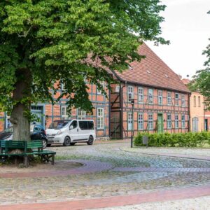 Einige Fachwerkhäuser bei einem Runden Platz in Plau am See.