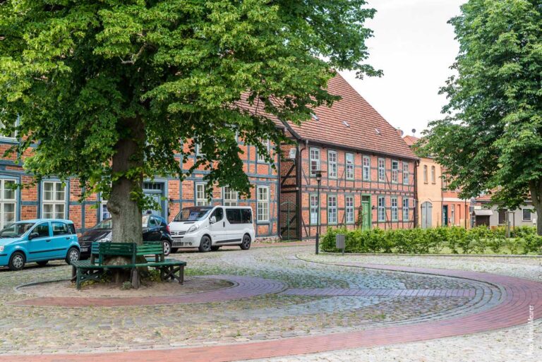 Einige Fachwerkhäuser bei einem Runden Platz in Plau am See.