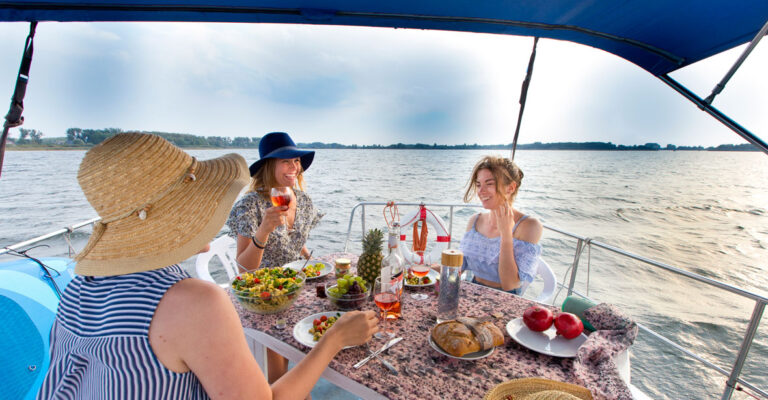 Drei Frauen auf dem Sonnendeck einer Vetus beim Abendessen