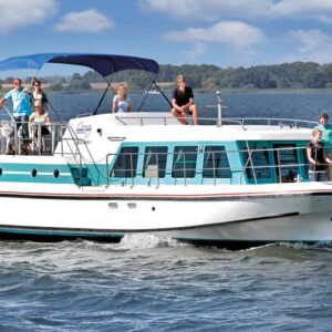 Eine Großfamilie auf dem Deck der Vetus 1500 verteilt. Die meisten Personen sind hinten auf dem Sonnendeck, welches durch ein blaues Bimini geschützt ist.