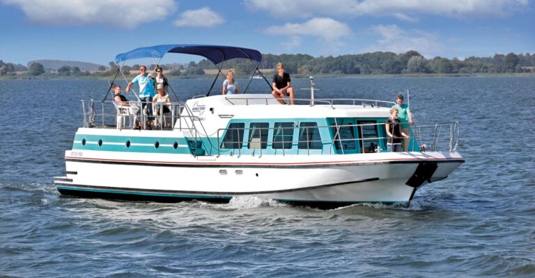 Eine Großfamilie auf dem Deck der Vetus 1500 verteilt. Die meisten Personen sind hinten auf dem Sonnendeck, welches durch ein blaues Bimini geschützt ist.