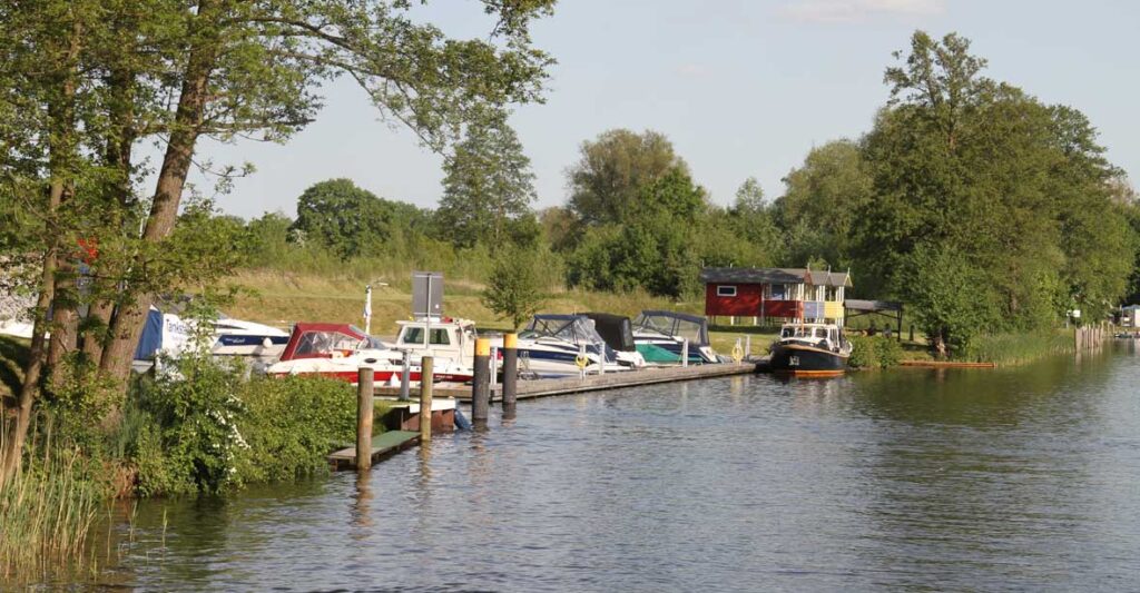 ein Fluss mit Blick auf eine kleine Marina, in der Boote liegen