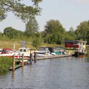 ein Fluss mit Blick auf eine kleine Marina, in der Boote liegen