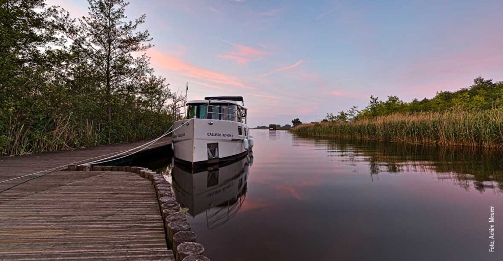 Hausboot in Wesenberg am Abend, es liegt an einem Steg an