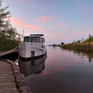 Hausboot in Wesenberg am Abend, es liegt an einem Steg an