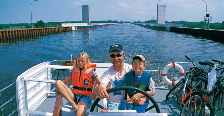 Ein Vater am Steuer einer Vetus mit seinen Kindern