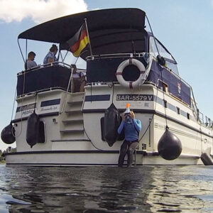 Heckansicht der Pedro Levanto. eine Person sitzt unten auf der Badeplattform und bereit sich aufs Tauchen vor.