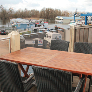 Großer Balkon mit Tisch und Blick auf den Hafen.