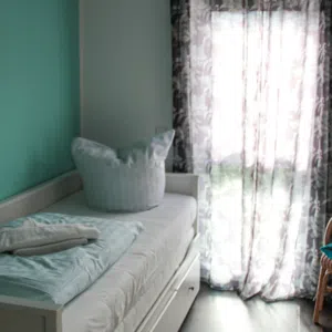 Zimmer mit Einzelbett und Kleiderschrank