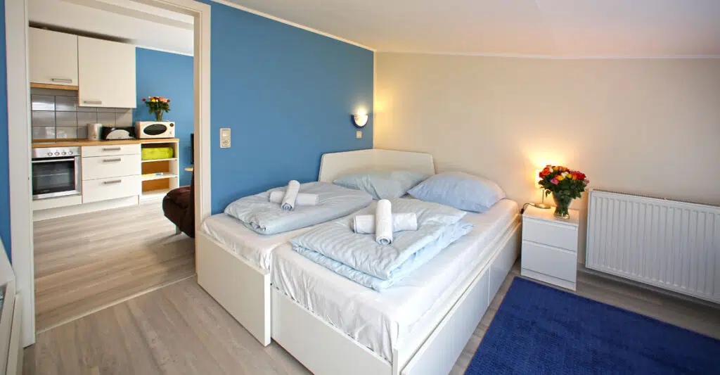 Ein bezogenes Doppelbett in einer Ferienwohnung in Niderviller.