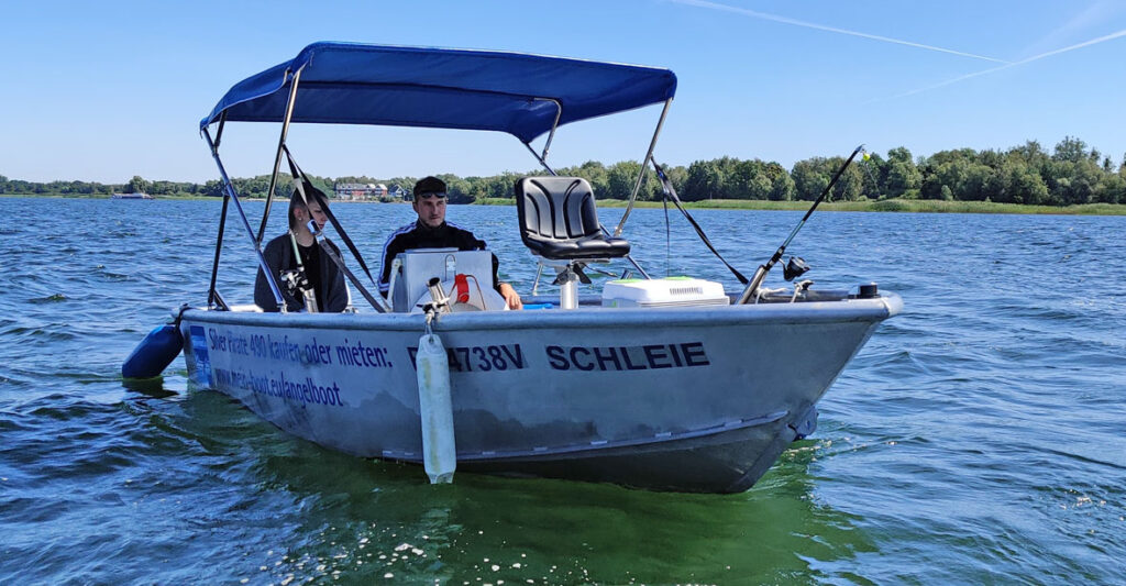 ein Paar sitzt in einem Boot und fährt zum Angeln auf den See