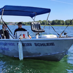 ein Paar sitzt in einem Boot und fährt zum Angeln auf den See