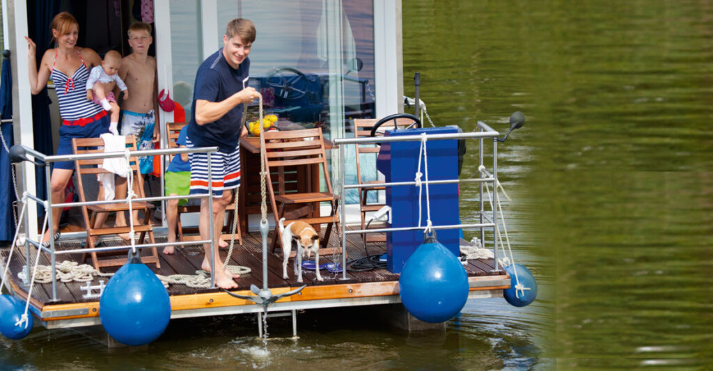 Hausboot mit einer Mutter und 3 Kindern auf der Badeplattform